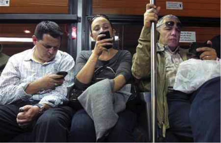 People on their phones on a train