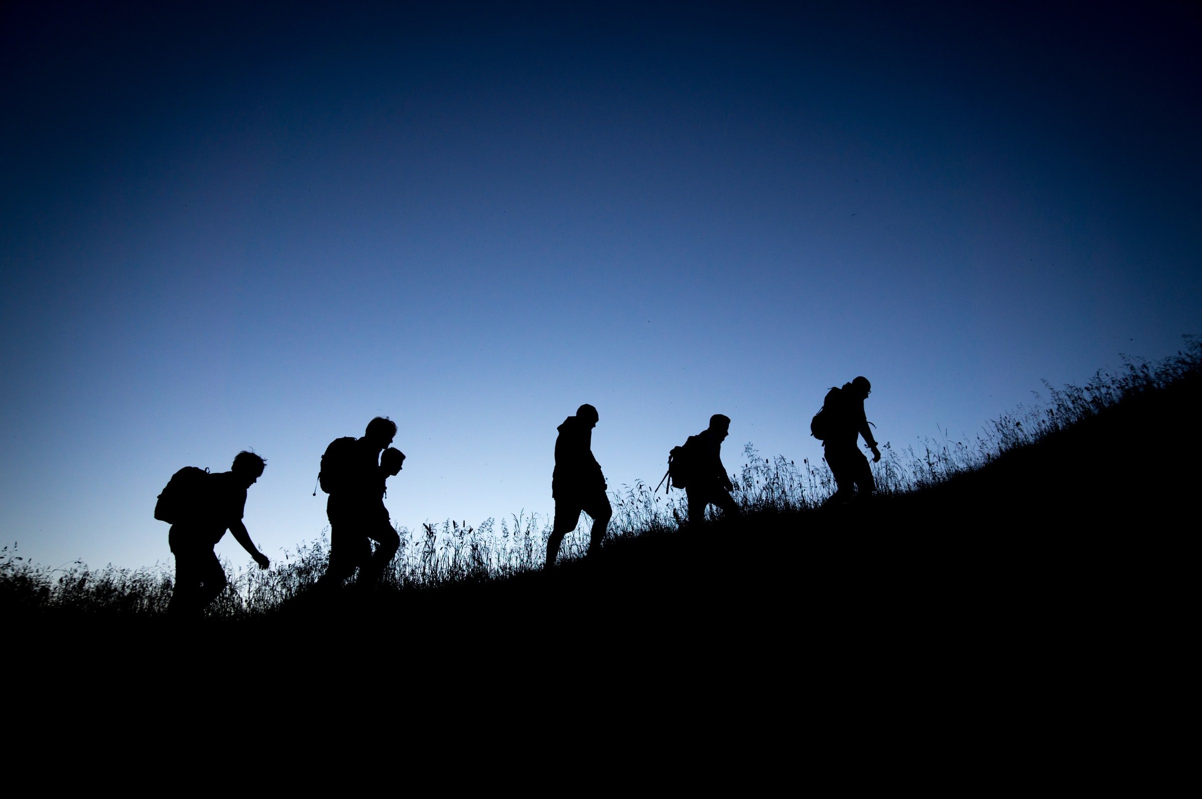 group of people climbing a hill