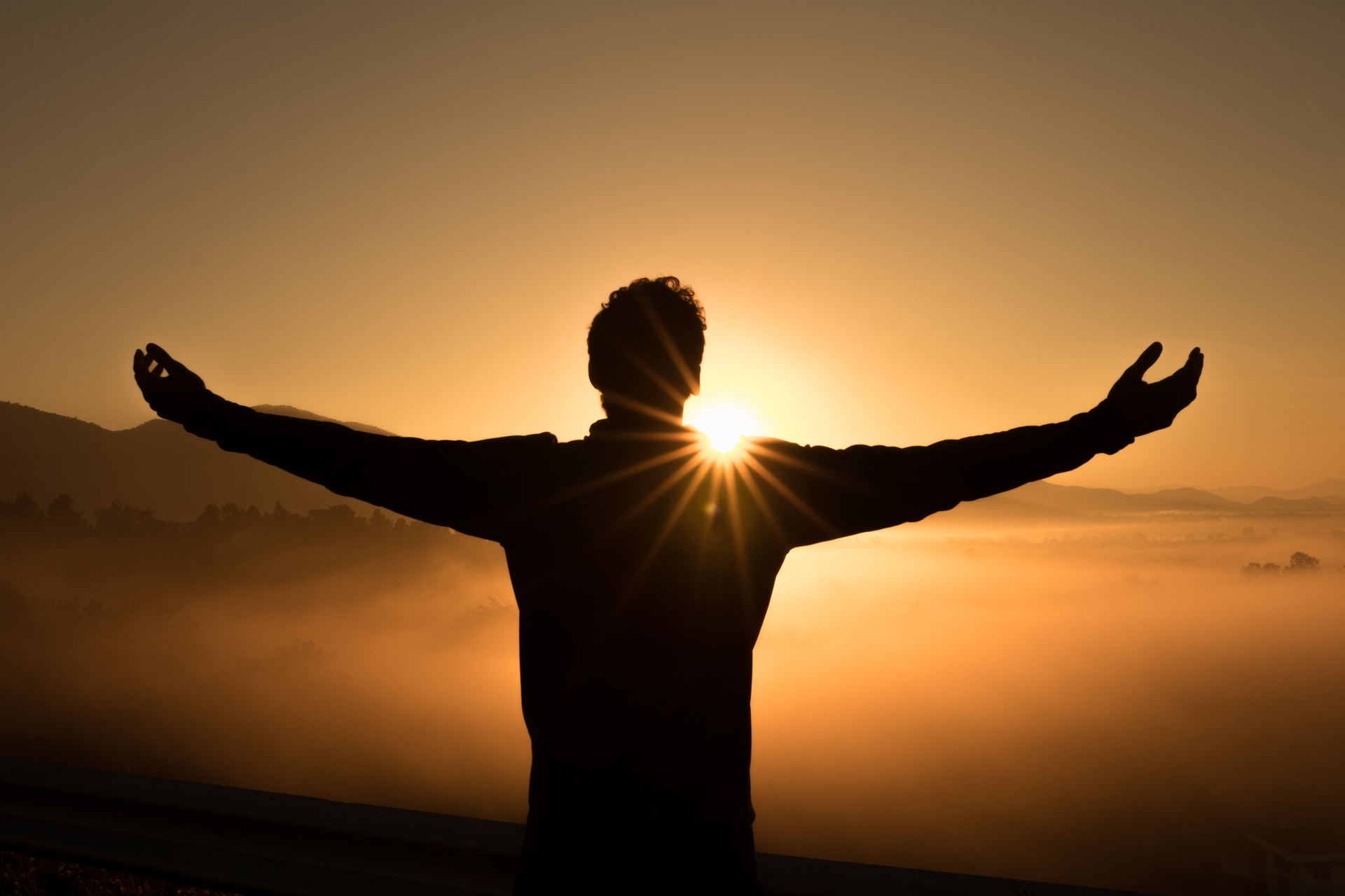 silhouette image of man standing in front of sun